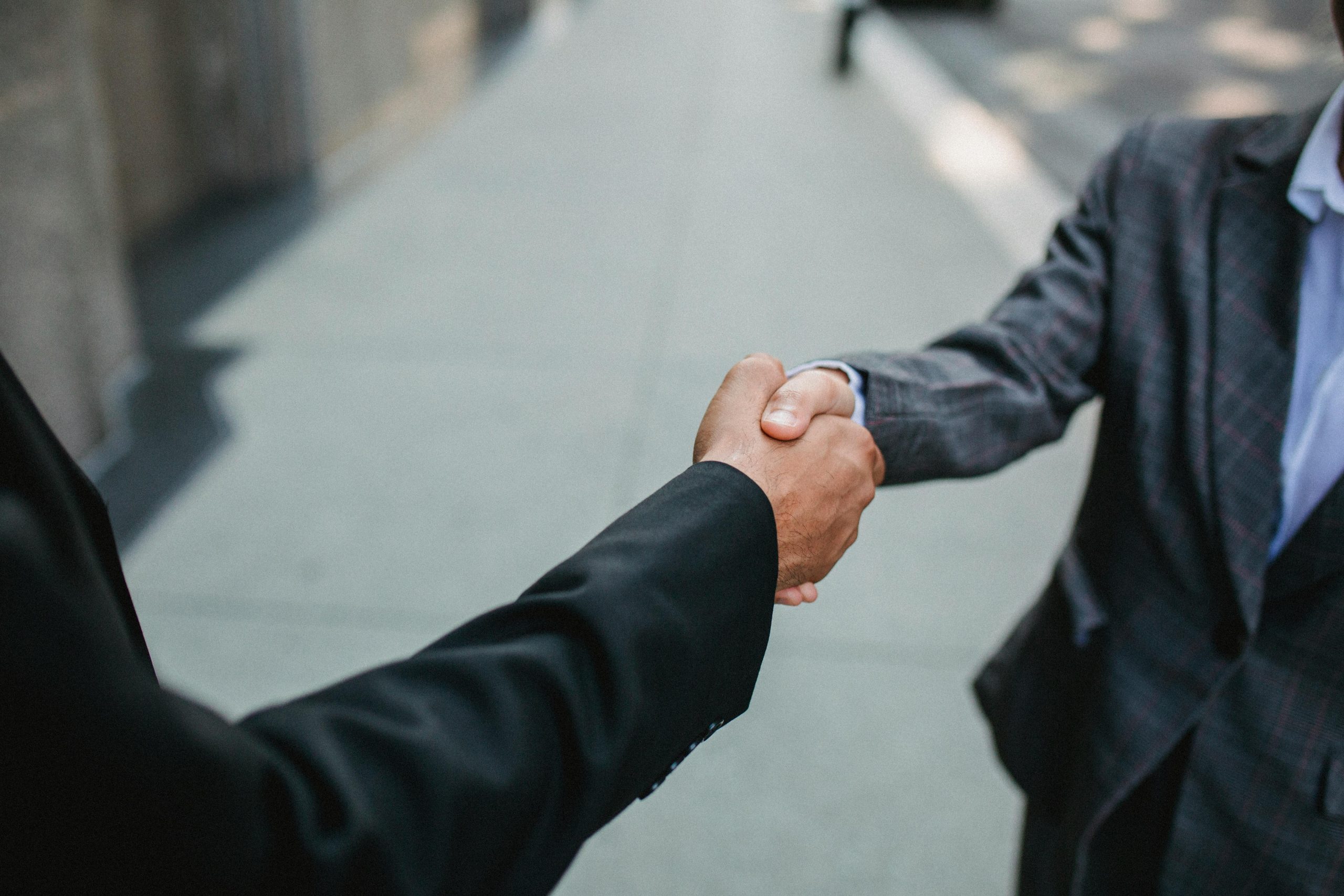 Home Close-up of two businessmen shaking hands outside, symbolizing partnership and agreement.